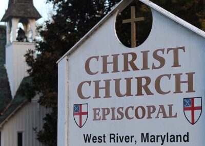 A sign reads "Christ Church Episcopal" in West River, Maryland, established in 1867; a church building is visible in the background.